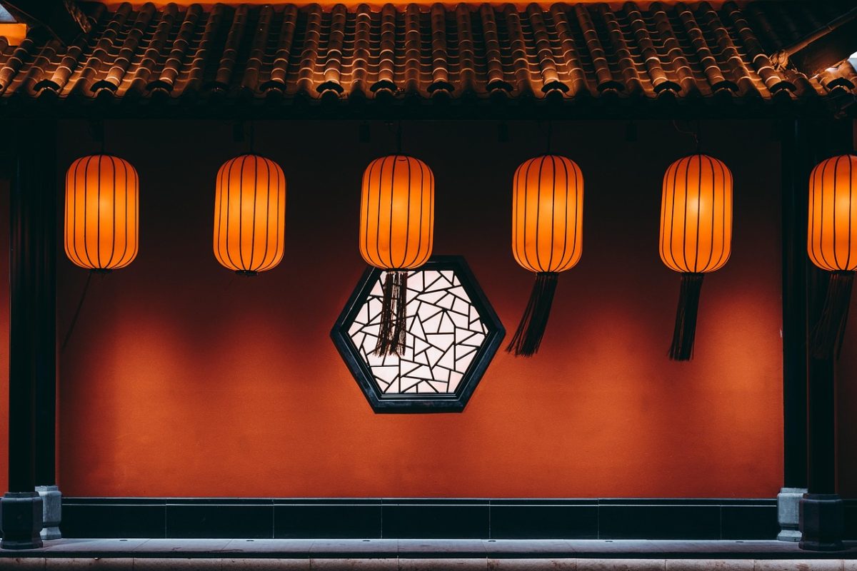 开云中国 编辑部工作台实景：木质桌面上摊开的纸质资料与笔记本，午后暖光从窗边斜射进来，角落放着一杯还冒着热气的茶，整体呈现复古怀旧的暖棕色调，安静专注的整理氛围